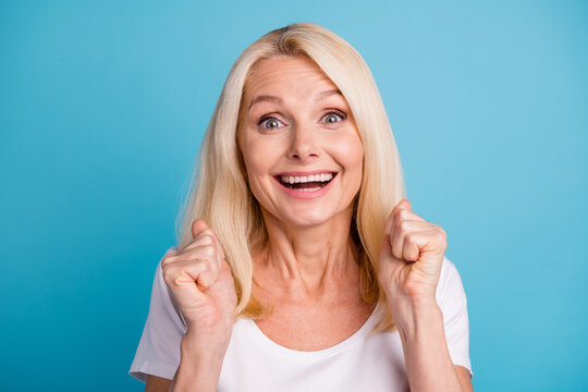 Portrait of excited old woman raise fists scream wear good look clothes isolated over blue color background