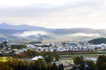 北海道虻田郡京極町のふきだし公園から見た、朝霧の中朝日を浴びて輝く京極の家々
