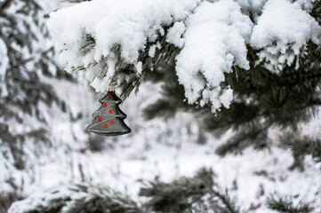 Naklejka premium Christmas background with a black Christmas tree toy on a snow-covered pine branch with a copy space. New year holiday, christmas celebration, greeting card. Gothic Christmas style