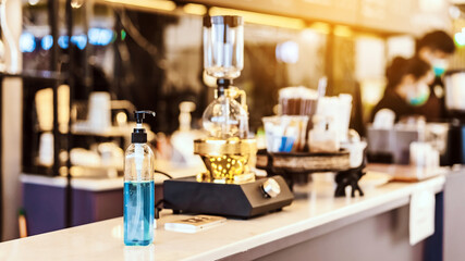 Blue alcohol gel bottle for hands cleaning to prevent the spreading of the Corona virus (Covid-19), Place the entrance service for customers  in the cafe. Healthcare concept. New normal lifestyle.
