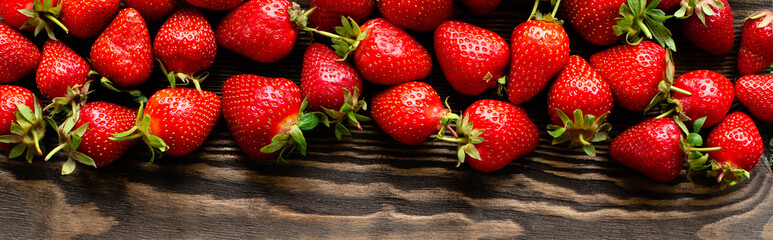 red raw fresh strawberries on wooden background, close view 