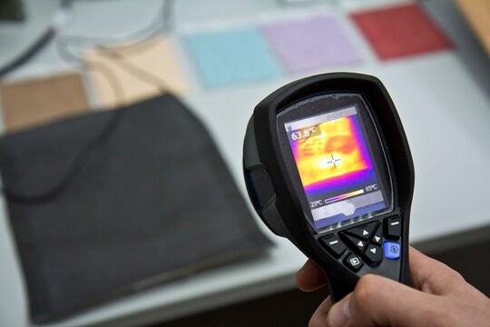 ULYANOVSK, RUSSIA - DECEMBER 17, 2015: Close-up of male hand using infrared thermal camera. Menu is in russian language.