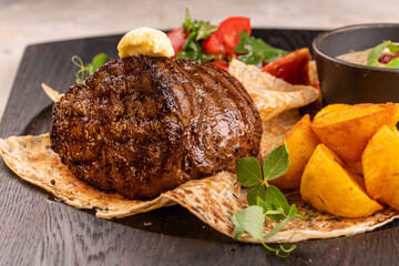 Fried beef fillet medallion steak close up on a wooden cutting board