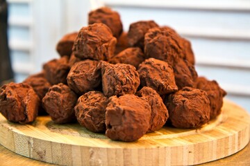 Close view of delicious sweet truffles on wooden trivet.