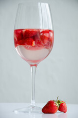 beverage with red raw fresh strawberries in wineglass, close view 