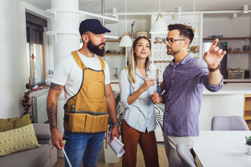 Naklejka premium The young couple talks to the master about renovating the apartment