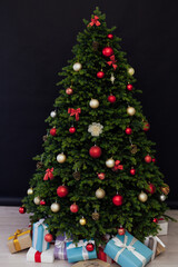 Obraz na płótnie Canvas Christmas tree pine with gifts for the new year black decor winter