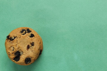 cookies with chocolate drops are stacked top view on a green grassy background of copy space