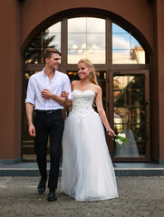 Young happy couple in love together on their wedding day stroll in blooming green garden