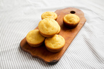 Homemade Cornbread Muffins on a rustic wooden board, low angle view.