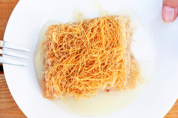 Plate with piece of kadaif dessert from above.