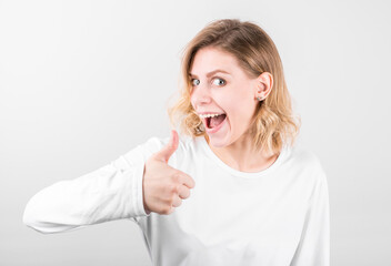 Young happy cheerful woman showing thumb up