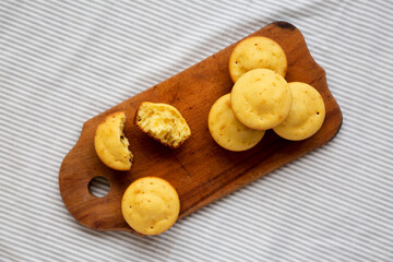 Homemade Cornbread Muffins on a rustic wooden board, overhead view. Flat lay, from above, top view.
