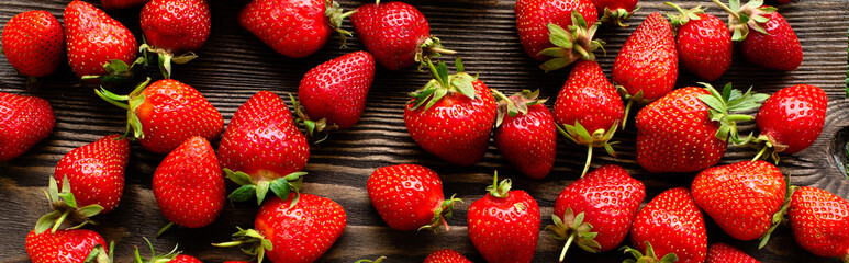 red raw fresh strawberries on wooden background, close view 