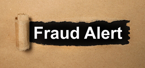 fraud alert, text on white paper on torn paper background