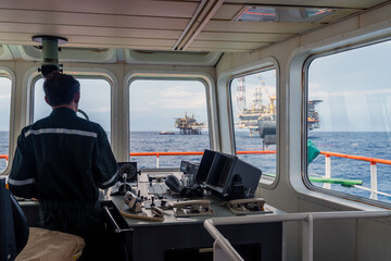 Offshore Terengganu oil field,, Malaysia - May 20, 2017: A supply boat captain maneuvering forward bridge while heading to a platform for transferring material and equipment at Terengganu oil field.