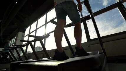 close-up of a man's legs, which stay in shape and have muscles, running on a treadmill with a lot of energy. Concept: sports, gym, muscle and fitness.