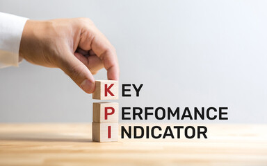 KPI text on wood box with male hand.business analysis