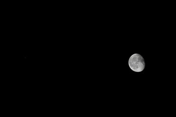 Mars (as a small red dot on the left) next to a waning gibbous moon in scale in one single picture