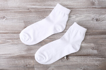 Twa, a pair of white cotton classic socks on wooden background