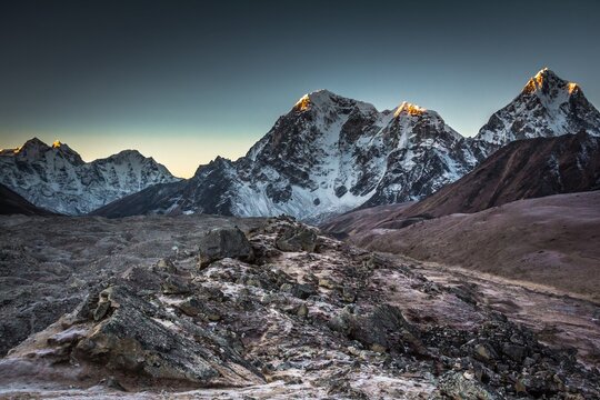 Taboche (6,495m) and Cholatse (6,440m) mountains in early morning which peaks lightened with first sun beams. The Himalaya mountains. Nepal.