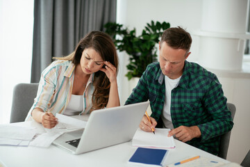 Husband and wife preparing bills to pay. Young couple having financial problems...