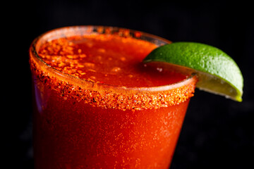 A delicious red cocktail, margarita, bloody mary with tahini and lime.