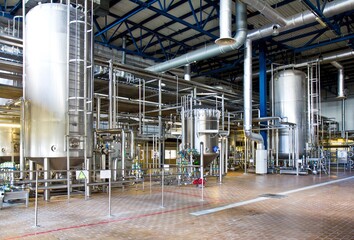 Production of beer: steel reservoirs and pipes in a brewery.