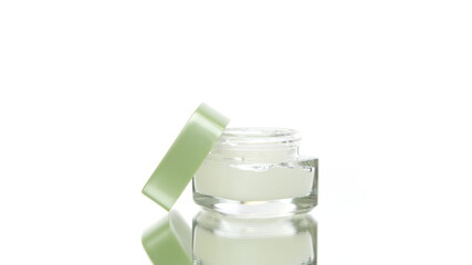 Premium cosmetic glass jar with cream rotating isolated on white background. Hydrating softening skin care routine, beauty, skip-care, natural cosmetic product in action, dermatology copy space