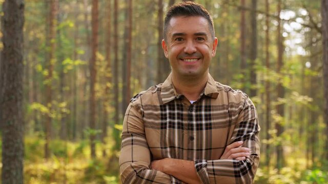 picking season and leisure people concept - happy smiling middle aged man in autumn forest