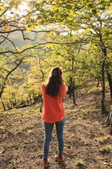 Young girl is taking pictures in the forest, beautiful autumn colors.