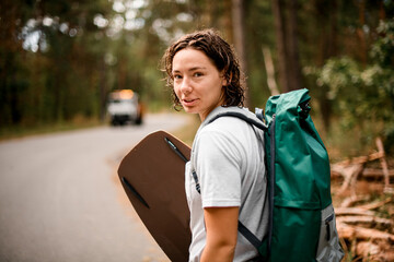 close-up of young beautiful girl with backpack and wakeboarding board