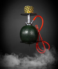 East smoking hookah. Arabian watermelon shisha. dark background with smoke