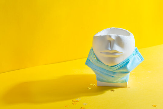 Empty plaster pot in the shape of face in medical mask.