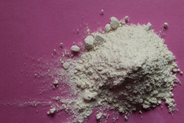 flour or powdered sugar is piled in a pile on a fuchsia pink background top view there is a copy space for the text