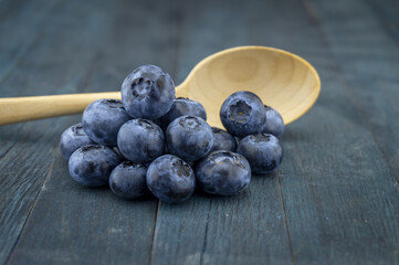 Bunch of fresh blueberries and wooden spoon