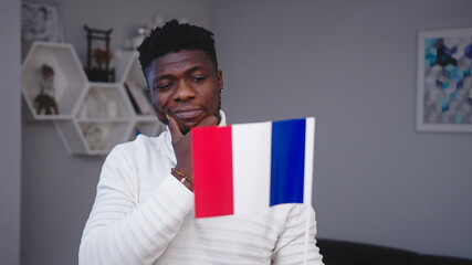Young black man with french flag. Student exchange program or work relocation concept. High quality photo