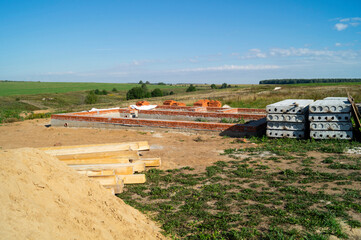 Fototapeta na wymiar Construction of the foundation for building in field on background blue sky