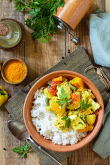 Fototapeta na wymiar Indian cuisine dish sabji. Traditional Indian vegetable stew with soft cheese, turmeric and rice on a wooden table.Top view flat lay background.