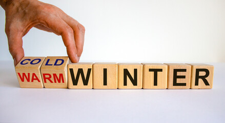 Predition for a cold winter. Hand turns cubes and changes the words 'warm winter' to 'cold winter'. Beautiful white background. Copy space.