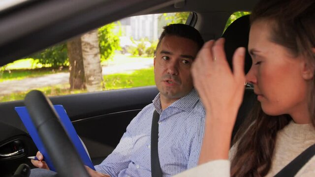 car driver courses and people concept - driving school instructor with clipboard talking to upset woman failed exam