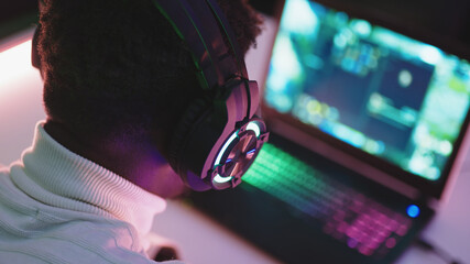 Black man using laptop at night. Social media chat or overworking concept. High quality photo © CameraCraft