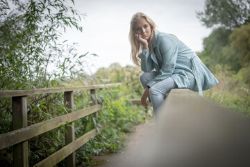 Fototapeta premium Thoughtful Young Woman Sitting On A Bridge
