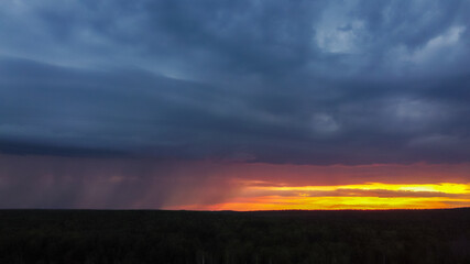 Thundercloud with rain at sunset. Dark blue sky