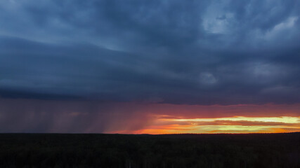 Thundercloud with rain at sunset. Dark blue sky