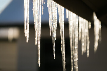 Icicles hanging from roof of house in winter