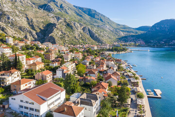 Aerial photo of the coastline of the Adriatic sea bay, small Montenegrin town. Water in the sea is turquoise, pure and clear. White boats swaying on the waves and yachts sailing on the sea