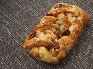 Puff pastry bun with sweet fruit and berry filling and pecan kernels.