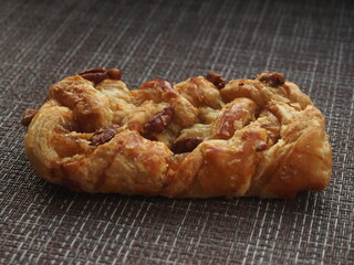 Puff pastry bun with sweet fruit and berry filling and pecan kernels.