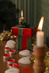 Christmas composition with candles and gifts in red packaging